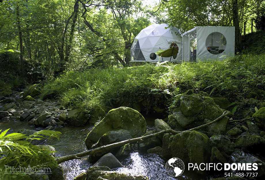 glamping dome tent next to a babbling brook